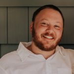 A photo of a smiling white man in a white shirt