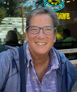 A photo of a white woman wearing glasses